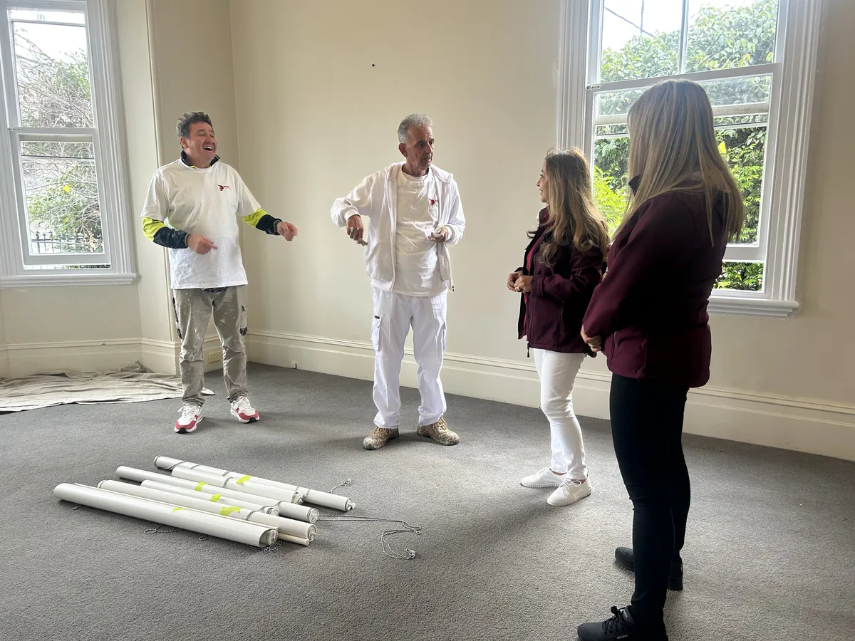 Affy Elzami and a colleague walking an empty room with two PaintX painters before work starts