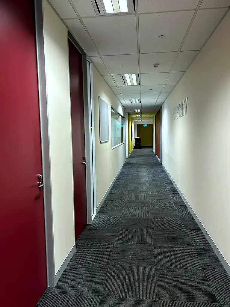 Office corridor with deep red doors and soft white walls