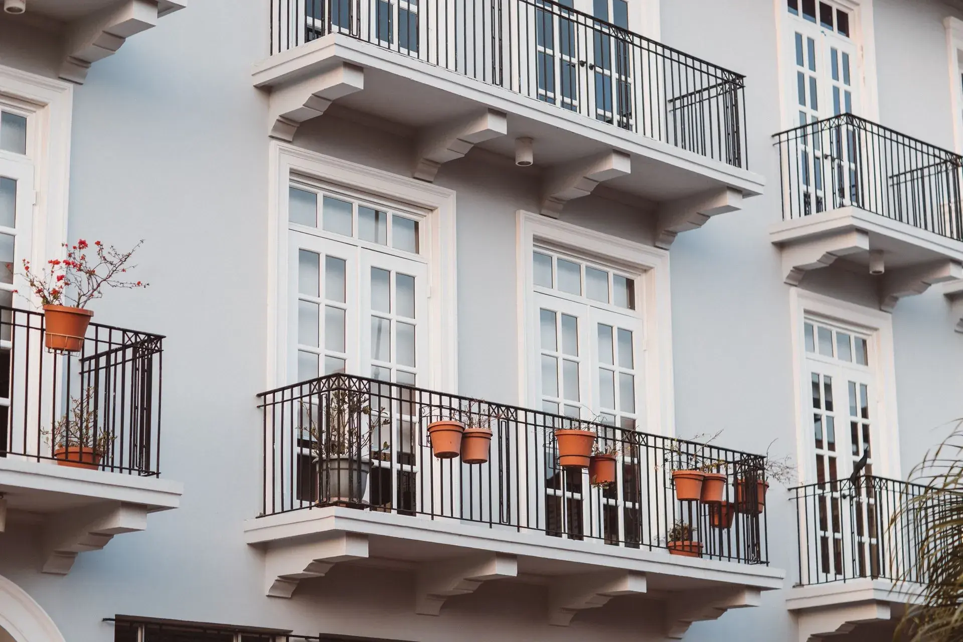 Apartment building with white render and black metal balcony railings