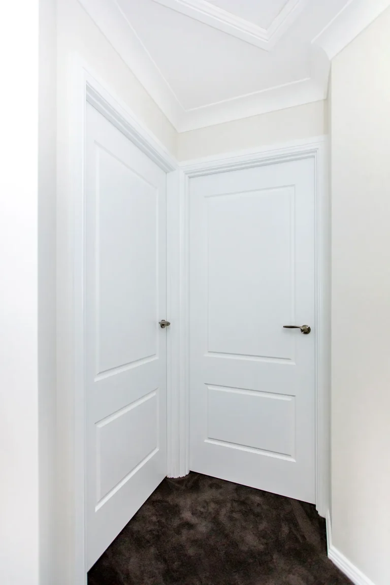 White panel doors and architraves at the end of a hallway